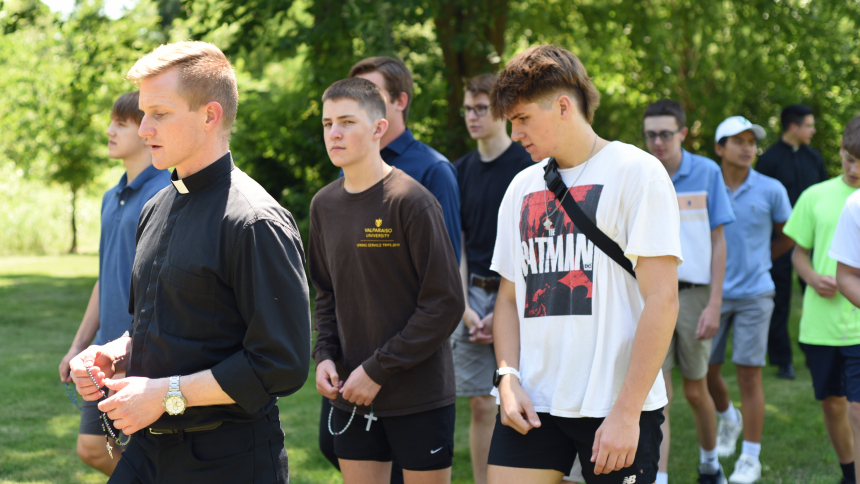 Facilitators such as Father Nathaniel Edquist (front, left), diocesan vocation director, lead discerners including brothers Porter Scott (center), 16, and Shepherd Scott (front, right), 17, on a Rosary walk during the Vocasti Me gathering on the St. Paul campus in Valparaiso on July 14. The event, Latin for “You have called me,” incorporated discussion, prayer and recreational activities for teen males who are considering a vocation to the priesthood. (Anthony D. Alonzo photo) 