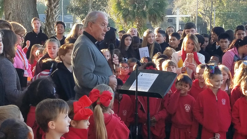 Msgr. Patrick Sheedy, pastor of Blessed Trinity Parish in Ocala, Fla., leads the Blessed Trinity School assembly in the lighting of the parish Christmas tree in December 2021. Father Pat, as he is best known, shepherds a stewardship-minded parish, which parishioners committed to in 1991. That led to the school being tuition-free three years later, and today Blessed Trinity has more than 100 stewardship opportunities in the parish and out into the community. (OSV News photo/courtesy Msgr. Patrick Sheed)