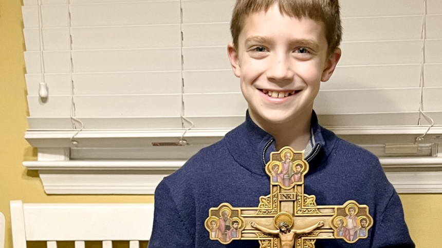 Dominic Auricchio, a fifth grader at  Holy Trinity School in Westfield, N.J., is pictured in an undated photo with seven religious items he received as Christmas gifts; a military Bible, a crucifix featuring the Stations of the Cross, a rosary, a miraculous medal, a vial of holy water, a chalice made of wood from the Holy Land and an Italian prayer card. Dominic had requested items from the Vatican. The Bible, holy water, rosary beads and crucifix came from the Vatican and were blessed by Pope Francis. (OSV
