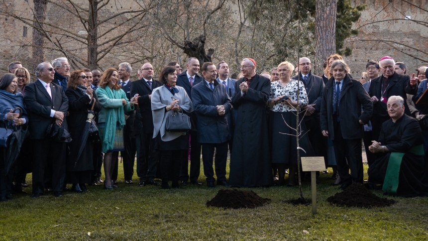 A group poses for a picture in the Vatican Gardens March 6, 2024, behind an apple tree planted to commemorate the Ulma family 80 years after their death on March 24, 1944, in Markowa, Poland, at the hands of German occupiers who killed the entire family for giving shelter to Jews in their house. Near the center is Cardinal Pietro Parolin, Vatican's secretary of state, with Wladyslaw Ortyl, marshall of Poland's Podkarpacie region, at left, and Grazyna Ignaczak -Bandych, chief of Cabinet to the president of P