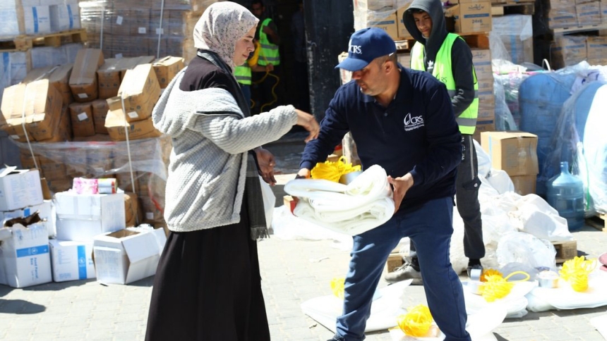A Catholic Relief Services worker distributes shelter material to a woman in Rafah, in the southern Gaza Strip, March 21, 2024, displaced by the ongoing conflict between Israel and Hamas. (OSV News photo/Mohammad Al Hout for CRS)