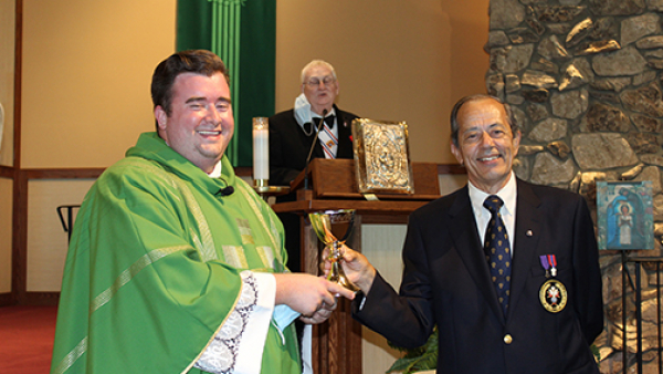 Father Jacob McDaniel and Virgil Pop pose with a chalice given to Father Jacob.